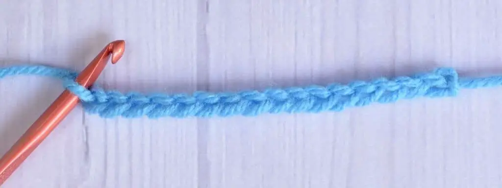 A crocheted foundation chain made of blue yarn