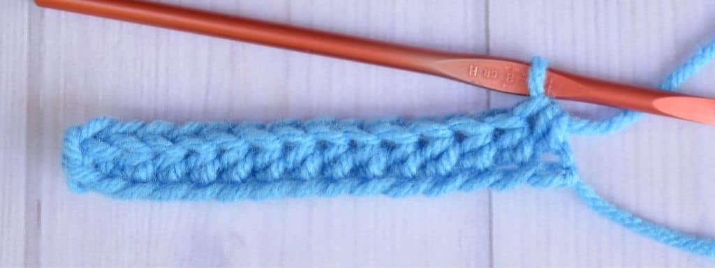 One row of half double crochet stitches made with blue worsted weight yarn