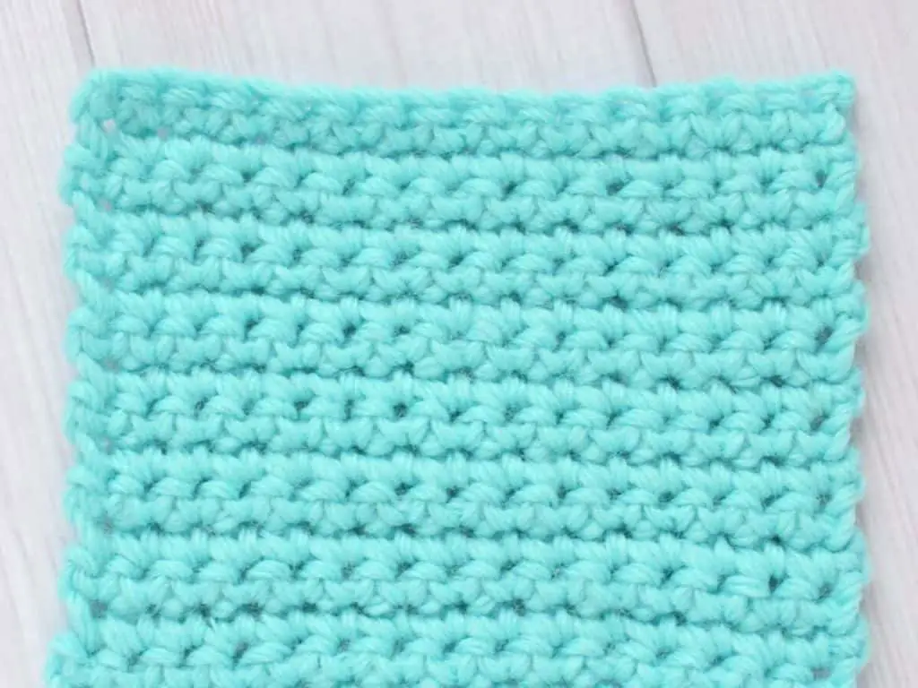 Swatch of blue yarn crocheted using the single crochet stitch
