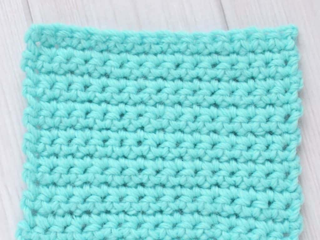 Swatch of blue yarn crocheted using the single crochet stitch