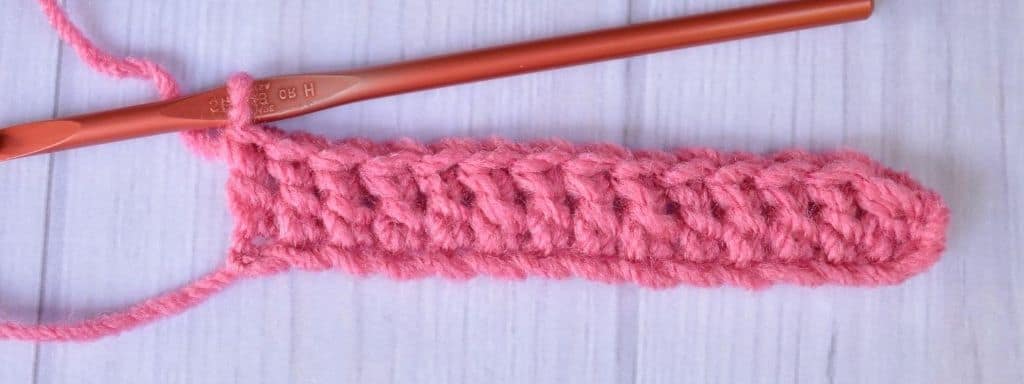 One row of double crochet stitches in pink yarn