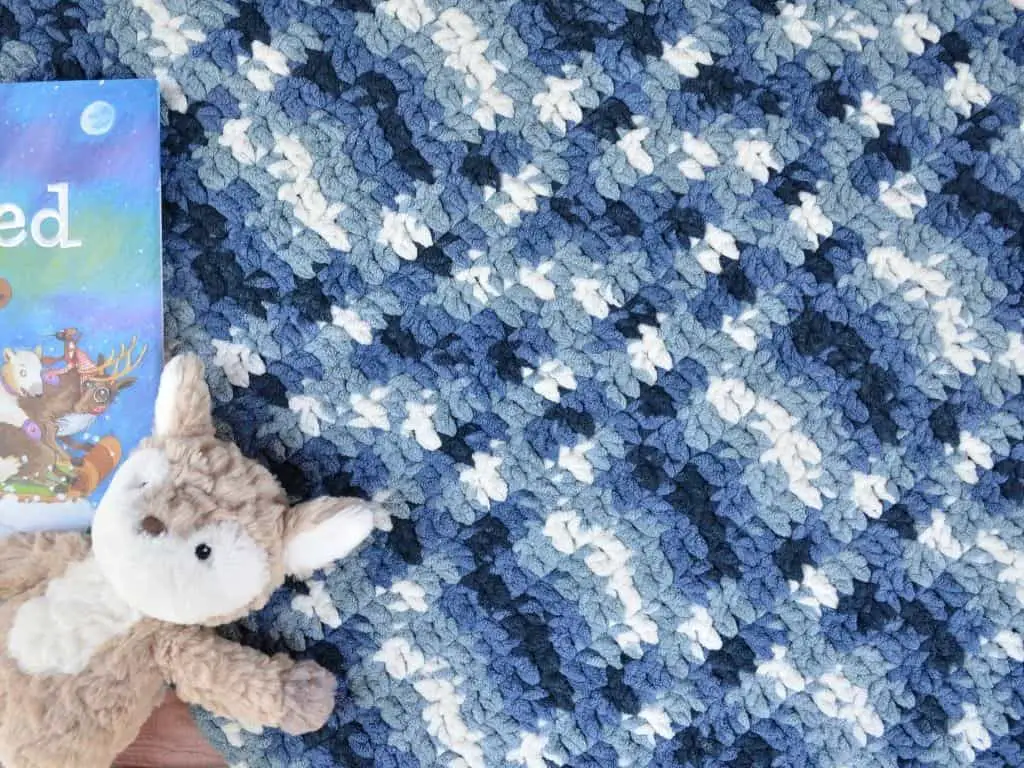Blue crochet baby blanket with stuffed fox toy