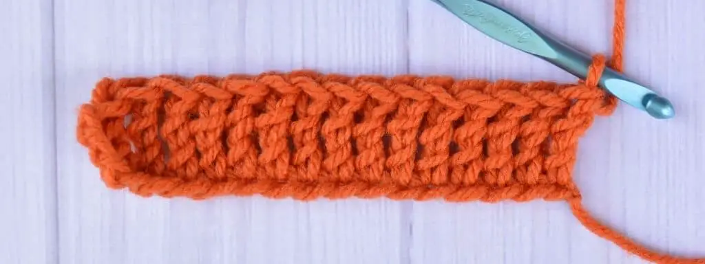 Swatch of the first row of treble crochet stitches by a left-handed crocheter