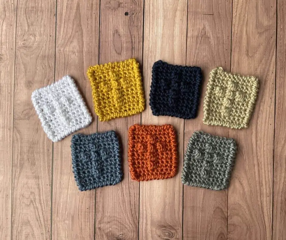 Several different crochet cross squares, each made in a different color.