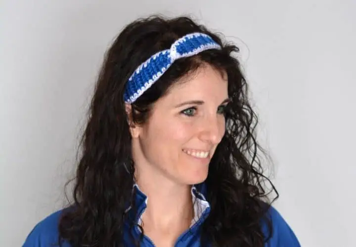 Woman wearing a crochet headband in royal blue with white border