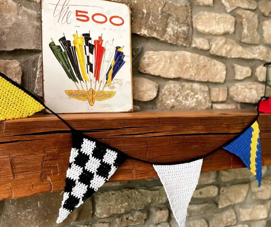A garland made of triangle pennants laid on a wooden background in a swirl