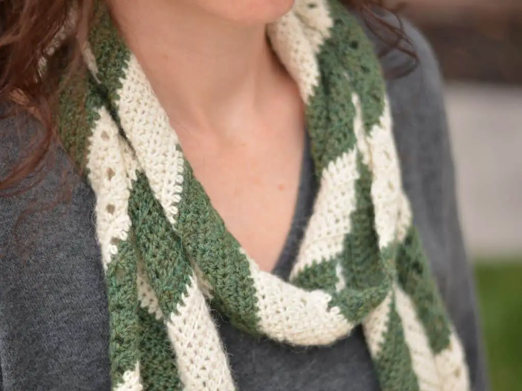 Closeup of a woman wearing a lightweight crochet scarf wrapped around her neck