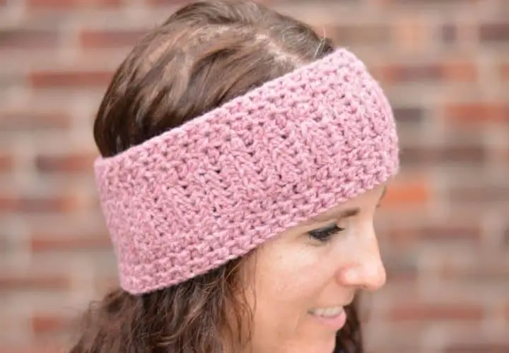 Side view of a young woman with heathered pink crochet ear warmer