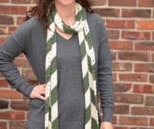 A woman wearing a long, skinny, crochet winter scarf