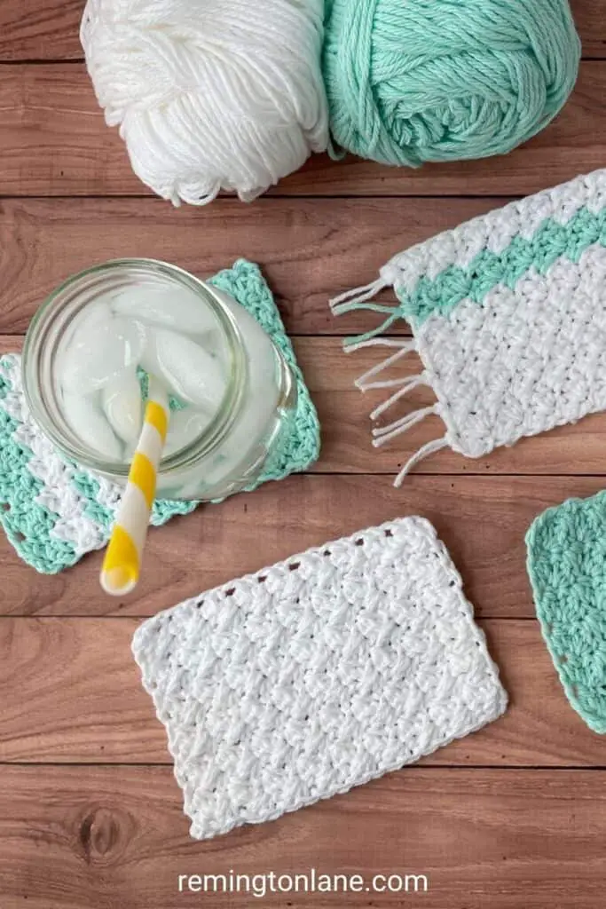 A table with crochet mug rugs and a glass of ice water sitting on top