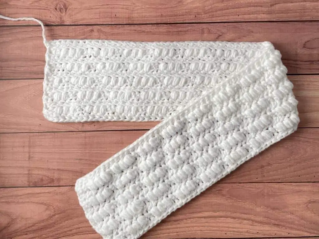 The front and back of a crochet ear warmer to show different textures