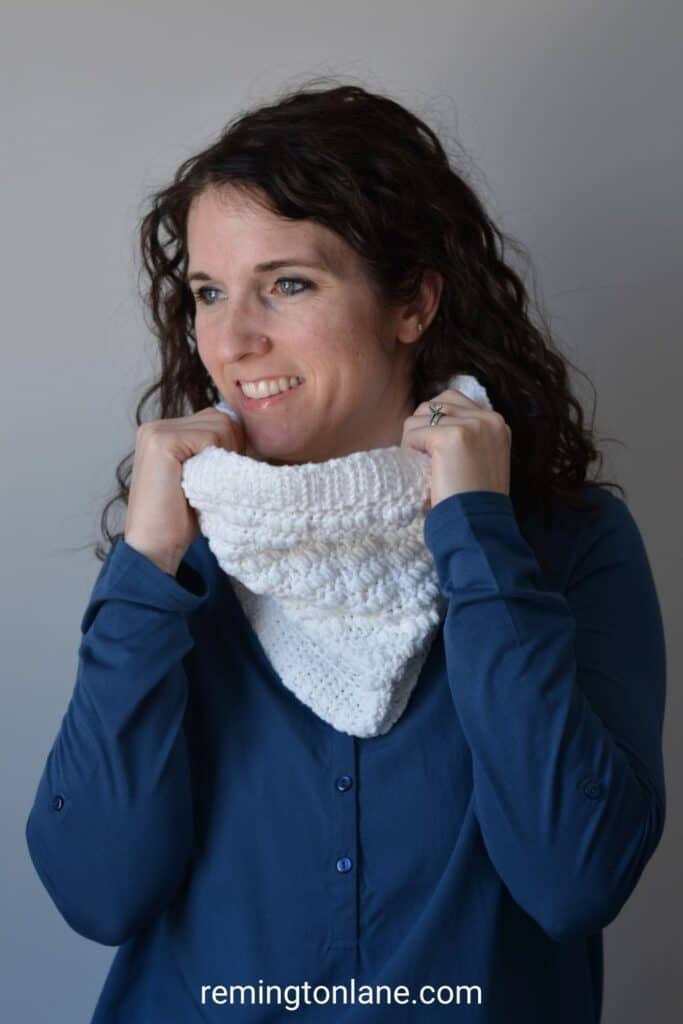 Smiling woman in a blue blouse wearing a white handmade cowl