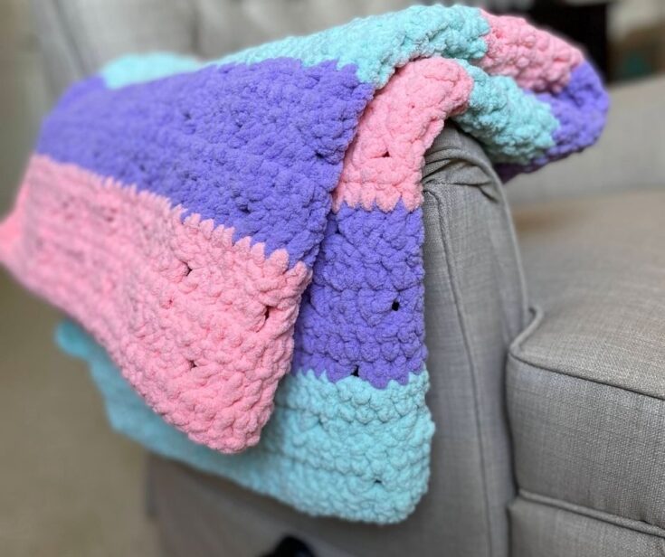 A striped blanket folded over the arm of a recliner chair