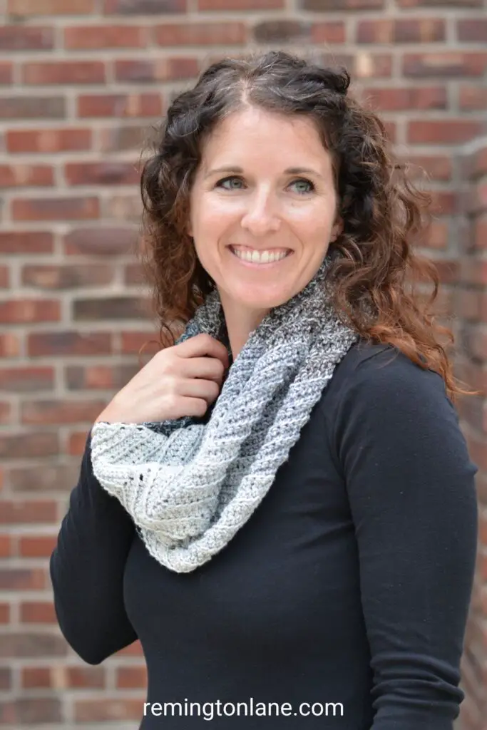 Woman wearing a grey ombre winter cowl with a black shirt