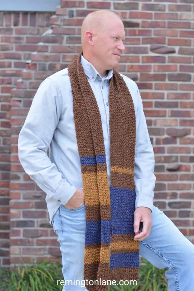 Man wearing a striped winter scarf in tones of brown and blue