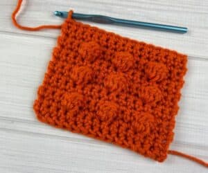 Crochet bobble stitches made from orange yarn in a small swatch.