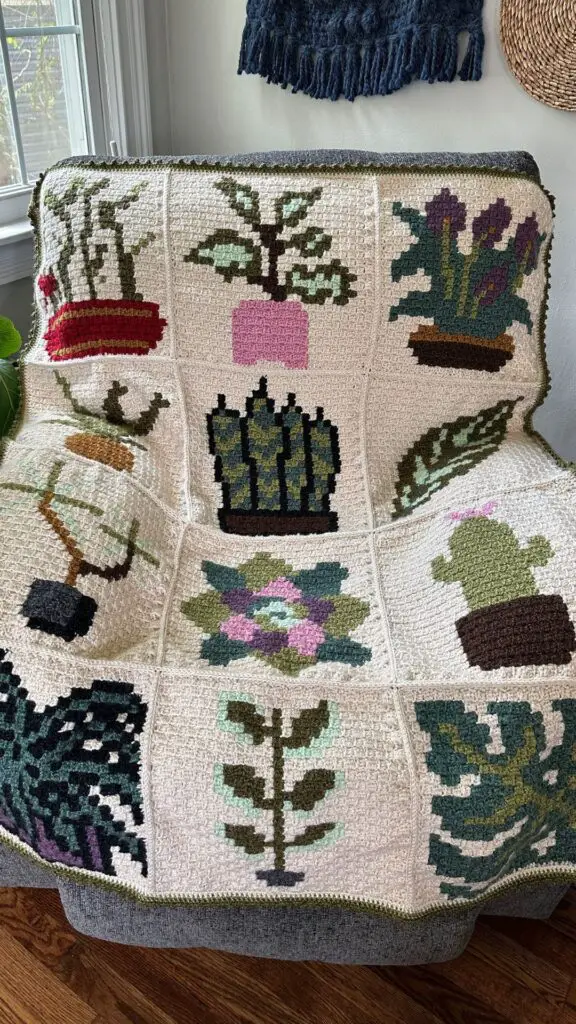 A crocheted blanket displayed on a chair in a living room