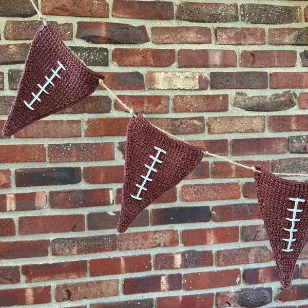 Three bunting flags that look like American footballs hanging on a rope