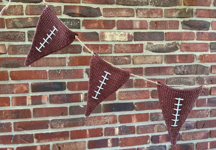 Three crochet football flags strung together with jute