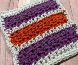 A close up of a small striped crocheted blanket square.