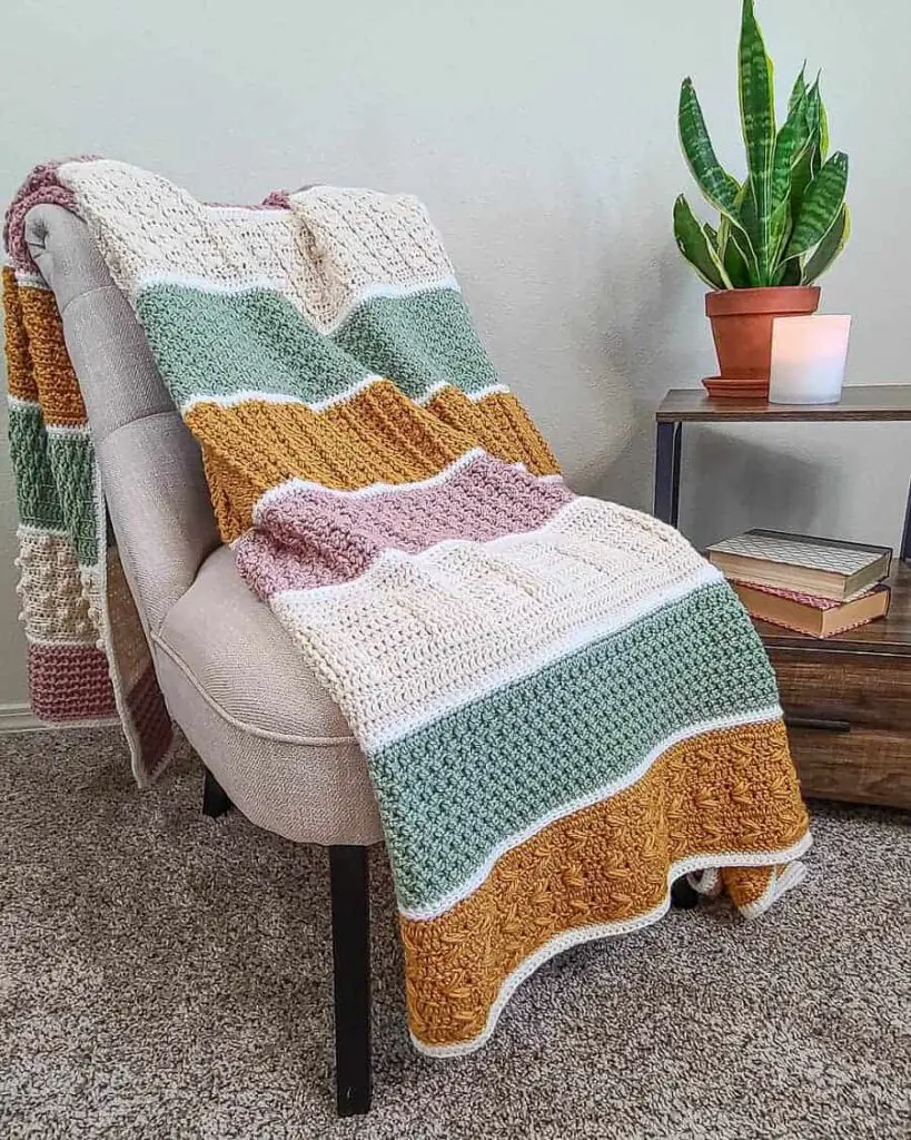 Textured crochet blanket laying across a chair.