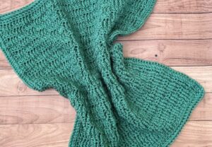 A blue-green squished blanket laying flat on a table.