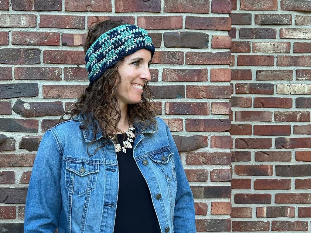 Smiling woman modeling a crocheted ear warmer