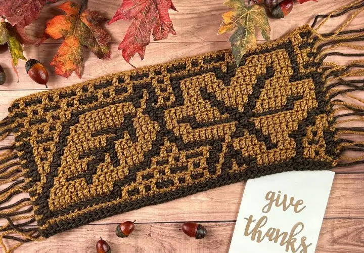 A mosaic sample made in two colors of brown yarn - dark and caramel - depicting two different tree leaves.